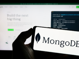 The MongoDB logo on a phone in front of the website.